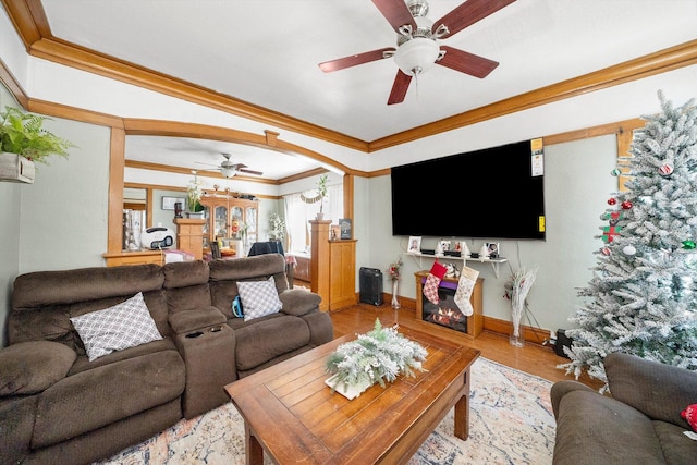 living room featuring crown molding, light hardwood / wood-style floors, and ceiling fan