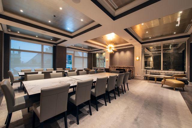 dining area featuring ornamental molding, coffered ceiling, light carpet, and an inviting chandelier