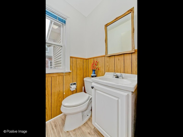 bathroom with wooden walls, vanity, toilet, and hardwood / wood-style floors