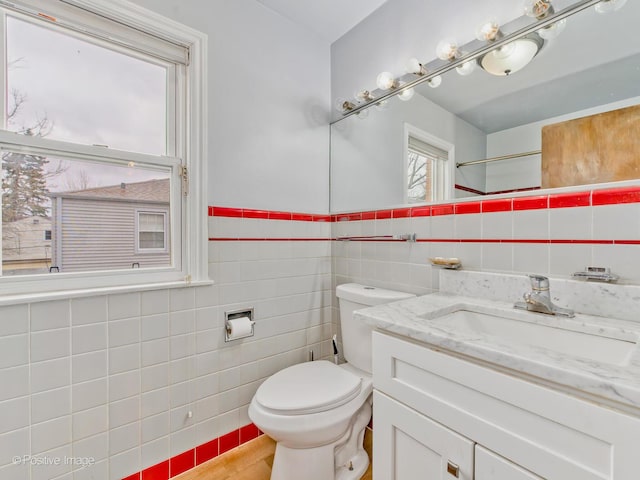 bathroom featuring tile walls, vanity, and toilet