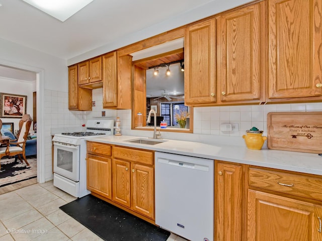 kitchen with tasteful backsplash, white appliances, sink, and light tile patterned floors