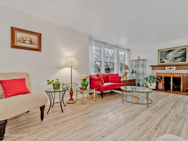 interior space with a tiled fireplace, crown molding, and light hardwood / wood-style floors