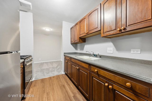 kitchen featuring stainless steel appliances, light hardwood / wood-style floors, and sink