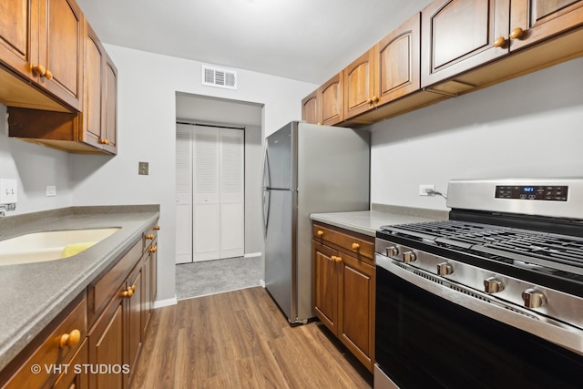 kitchen featuring sink, light hardwood / wood-style flooring, and stainless steel appliances