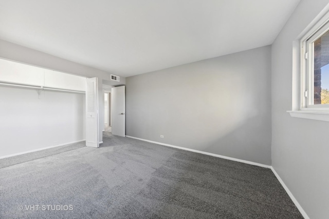 unfurnished bedroom featuring carpet and a closet