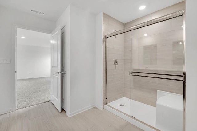 bathroom with a shower with door