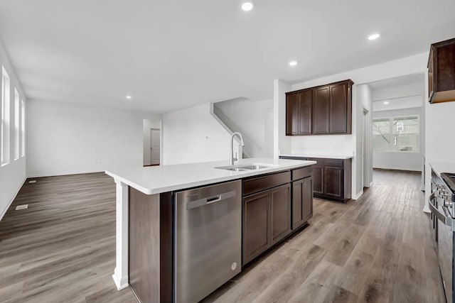 kitchen featuring sink, dishwasher, dark brown cabinetry, light hardwood / wood-style floors, and an island with sink