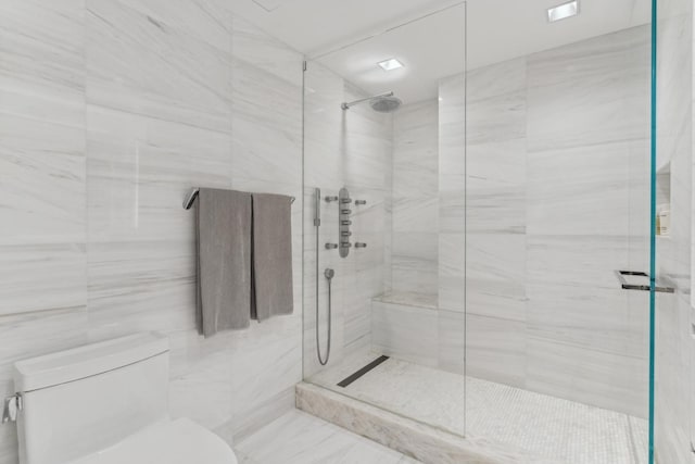 bathroom featuring a tile shower and toilet