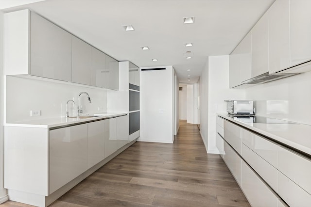 kitchen featuring white cabinetry, sink, electric stovetop, and light hardwood / wood-style floors