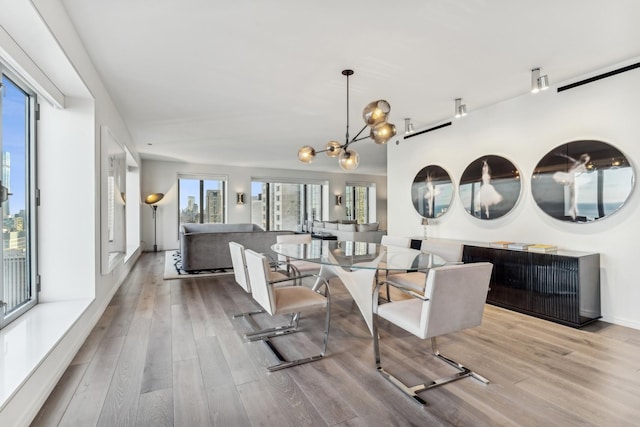 dining area with an inviting chandelier and light wood-type flooring