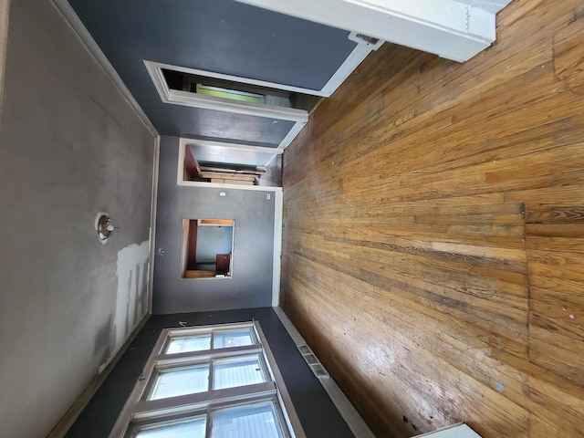 hall with beamed ceiling and wooden walls