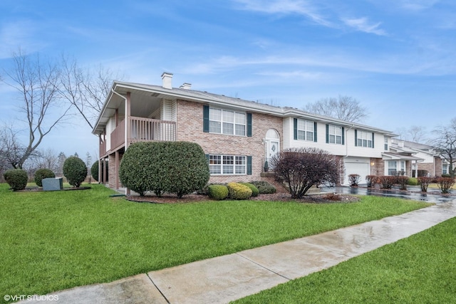 view of front of property featuring a garage, a front yard, and a balcony