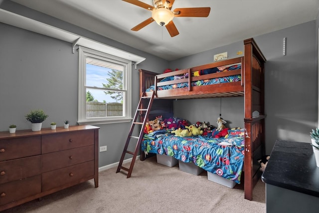 carpeted bedroom with ceiling fan and baseboards