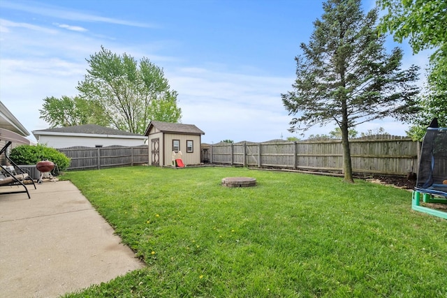 view of yard featuring a storage shed, a trampoline, an outdoor structure, and a patio