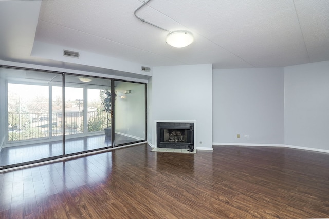 unfurnished living room with hardwood / wood-style flooring and a textured ceiling