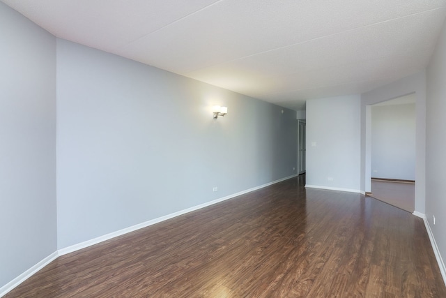 empty room with dark hardwood / wood-style flooring