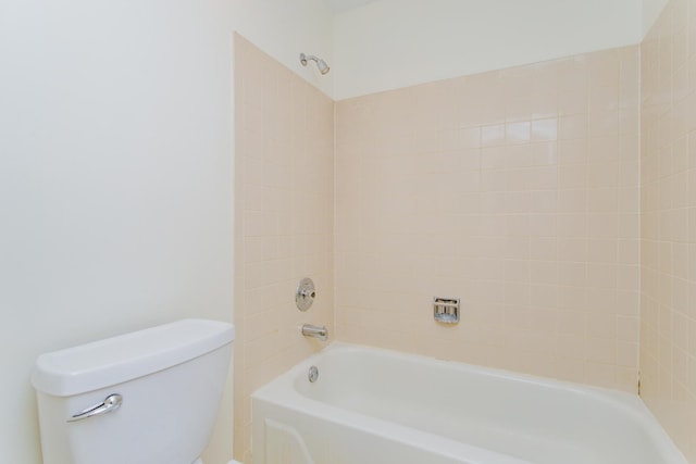 bathroom with tiled shower / bath combo and toilet