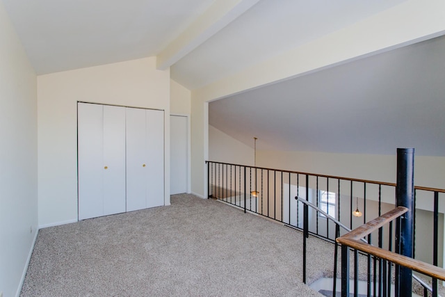 interior space with light colored carpet and lofted ceiling with beams