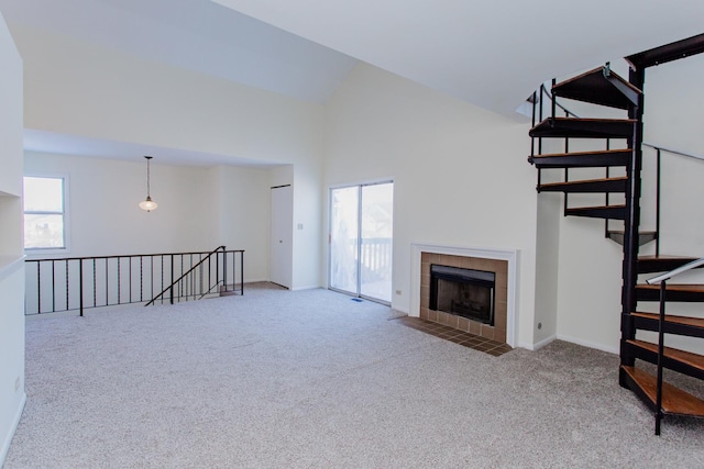 unfurnished living room with a fireplace, a wealth of natural light, light colored carpet, and high vaulted ceiling