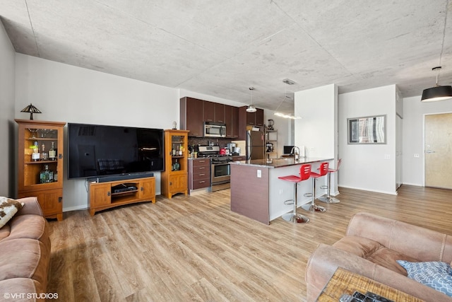 living room featuring sink and light hardwood / wood-style flooring