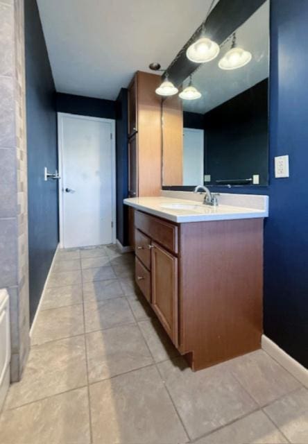 bathroom with tile patterned floors, baseboards, and vanity