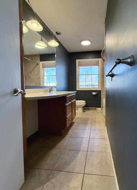 bathroom with tile patterned flooring, toilet, vanity, and baseboards