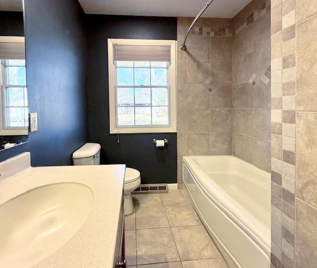 bathroom with tile patterned floors, toilet, tub / shower combination, and vanity