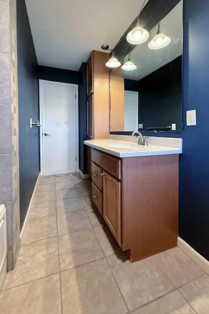 bathroom with vanity, tile patterned floors, and baseboards