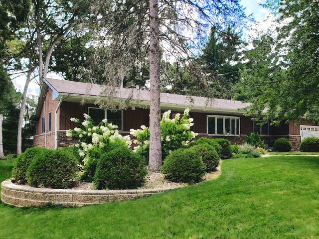 rear view of property featuring a garage, a lawn, and board and batten siding