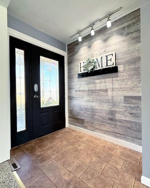 foyer entrance featuring visible vents and baseboards