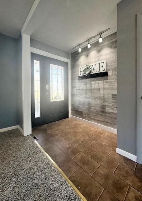 foyer with track lighting and baseboards