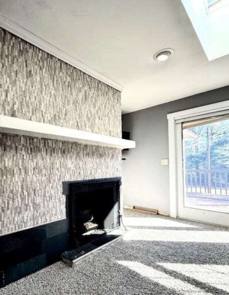 carpeted living room with a skylight and a large fireplace