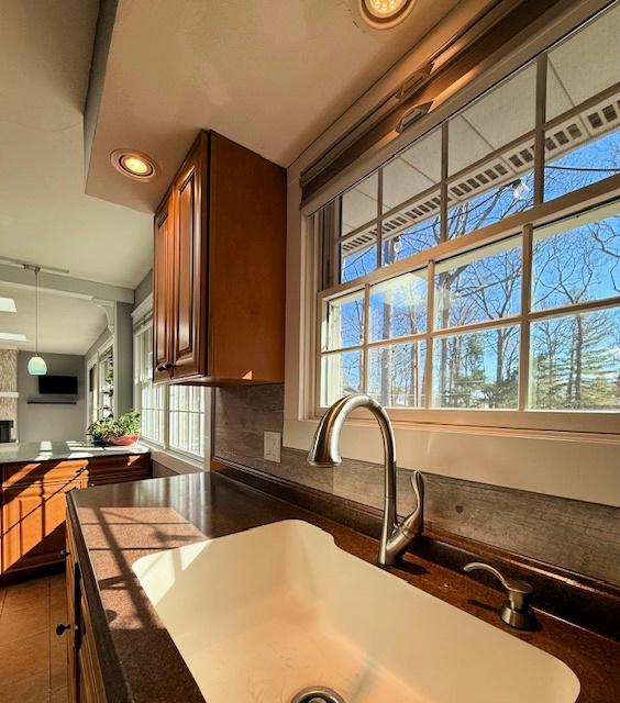 kitchen with dark countertops, decorative backsplash, open floor plan, and a sink