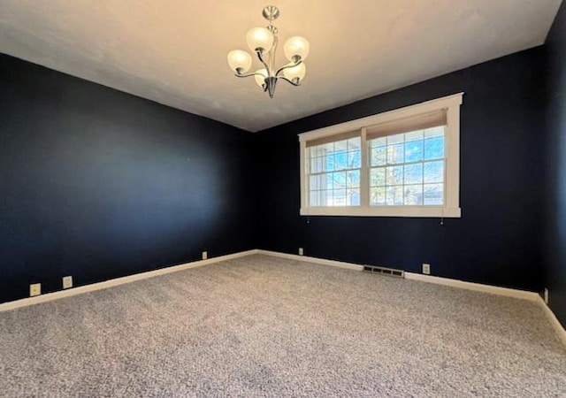 spare room featuring visible vents, baseboards, carpet floors, and an inviting chandelier