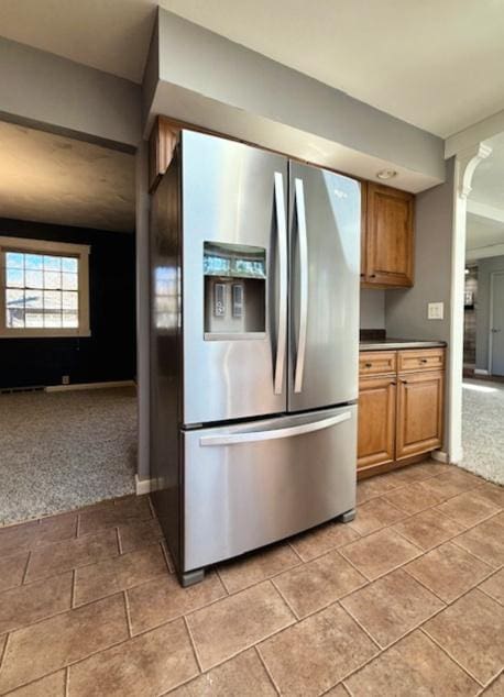 kitchen featuring light carpet, brown cabinets, and stainless steel fridge with ice dispenser