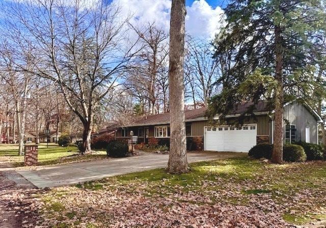 single story home with driveway, board and batten siding, and an attached garage