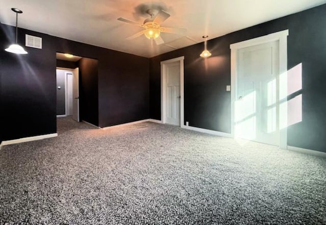 carpeted spare room featuring visible vents, baseboards, and a ceiling fan