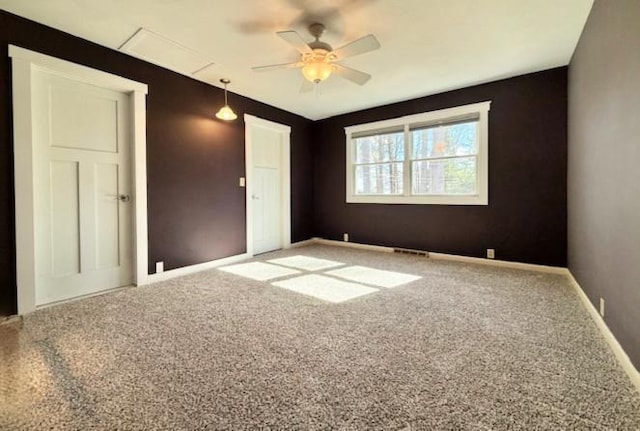 carpeted empty room featuring visible vents, baseboards, and ceiling fan