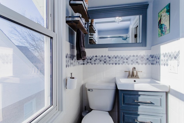 bathroom with vanity, tile walls, and toilet