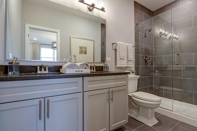 bathroom featuring vanity, a shower with shower door, tile patterned floors, and toilet