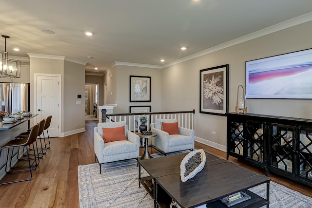 living room featuring ornamental molding, a notable chandelier, and light hardwood / wood-style floors