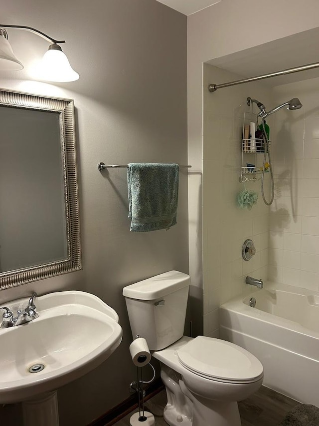 full bathroom with tiled shower / bath, sink, hardwood / wood-style floors, and toilet