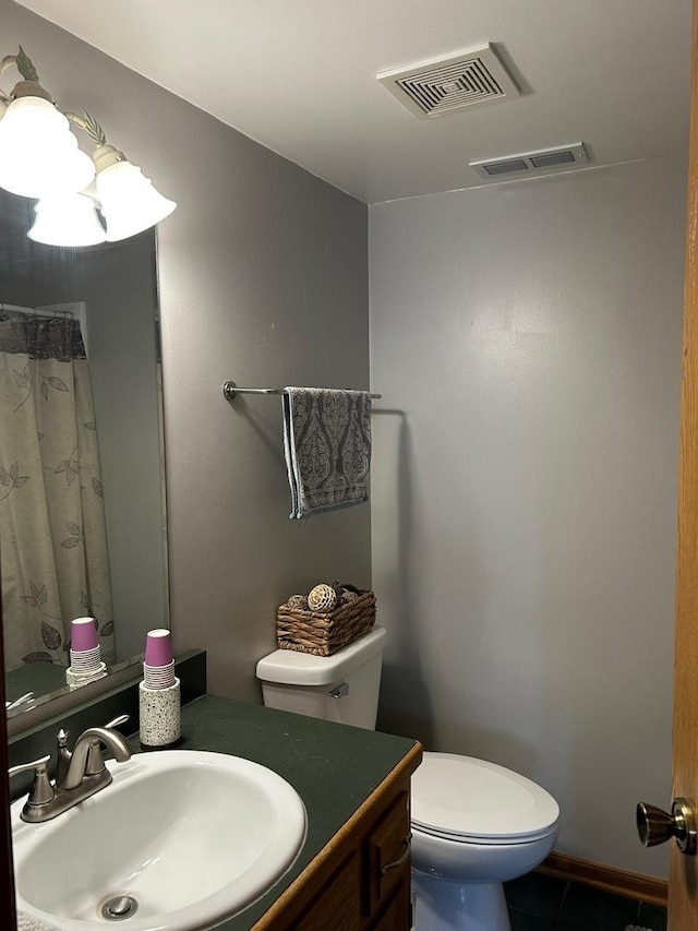 bathroom featuring vanity, toilet, and tile patterned flooring