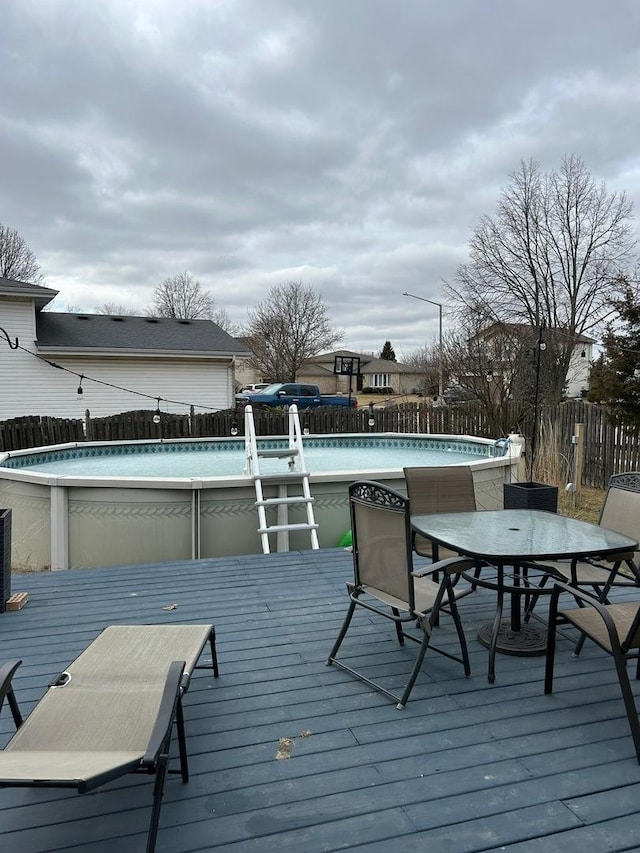 wooden terrace featuring a fenced in pool