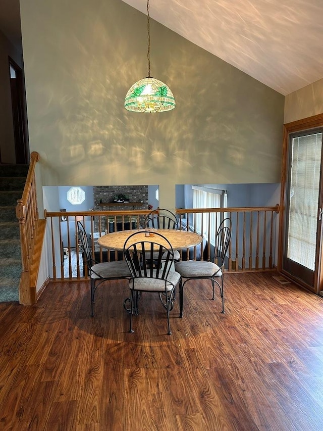 dining room with hardwood / wood-style flooring and vaulted ceiling