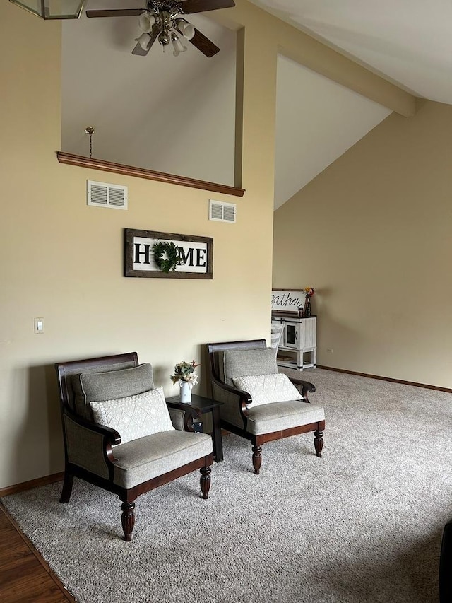 living area featuring ceiling fan, high vaulted ceiling, and beamed ceiling