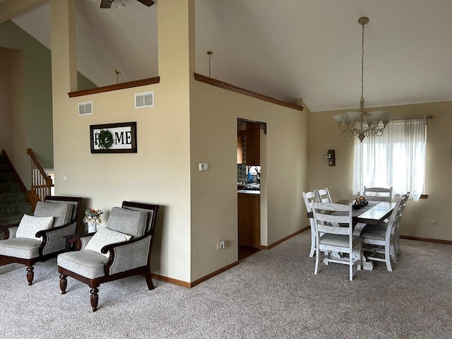 carpeted dining area featuring high vaulted ceiling and a chandelier