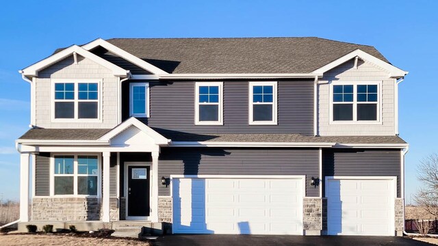 view of front of home with a garage and a lawn