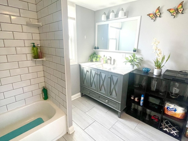 bathroom with tiled shower / bath combo, vanity, and tile patterned floors