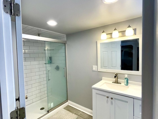 bathroom with a shower with door and vanity